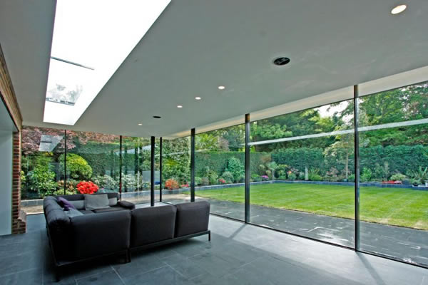 KELLER minimal windows® as floor to ceiling sliding glass walls to rear extension