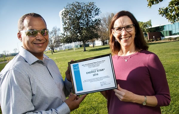 Vitro Architectural Glass employees Glen Collins, Fresno plant supervisor (left), and Wendy Garcia, environmental manager, receive an ENERGY STAR-labeled plant certificate for the company’s Fresno, California plant. 